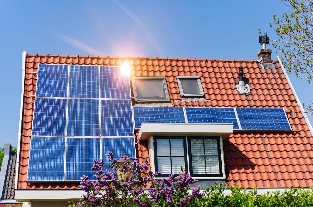 solar-panel-red-roof-reflecting-sun-cloudless-blue-sky-min-1200×800